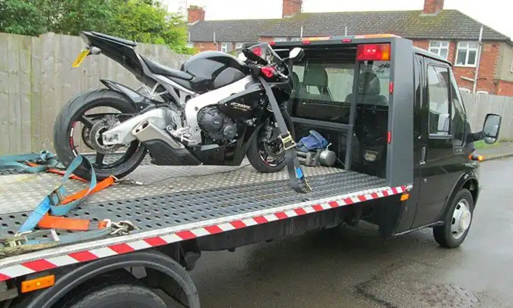 Motorcycle recovery — motorbike loaded onto flatbed recovery vehicle